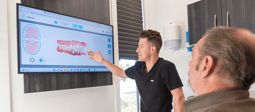 dentist showing a patient all on 4 dental implants