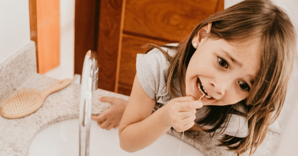 little girl trying to floss