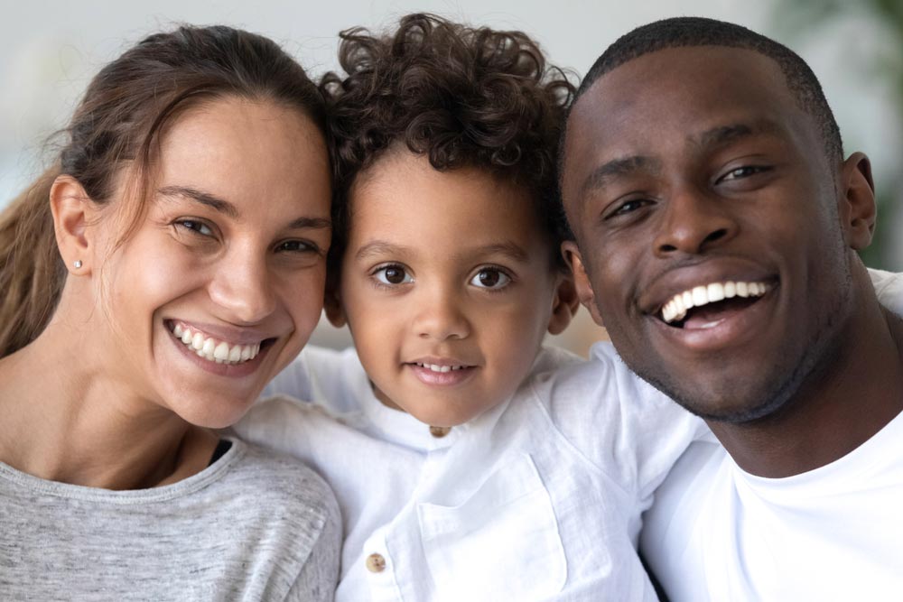 mother, father and son with healthy white smiles